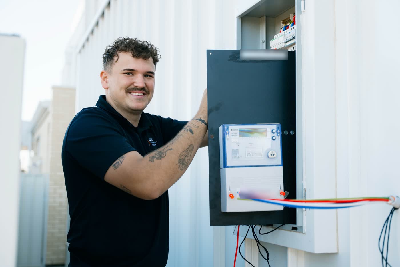 James from JJC Electrical at a home's meter box with new cabling